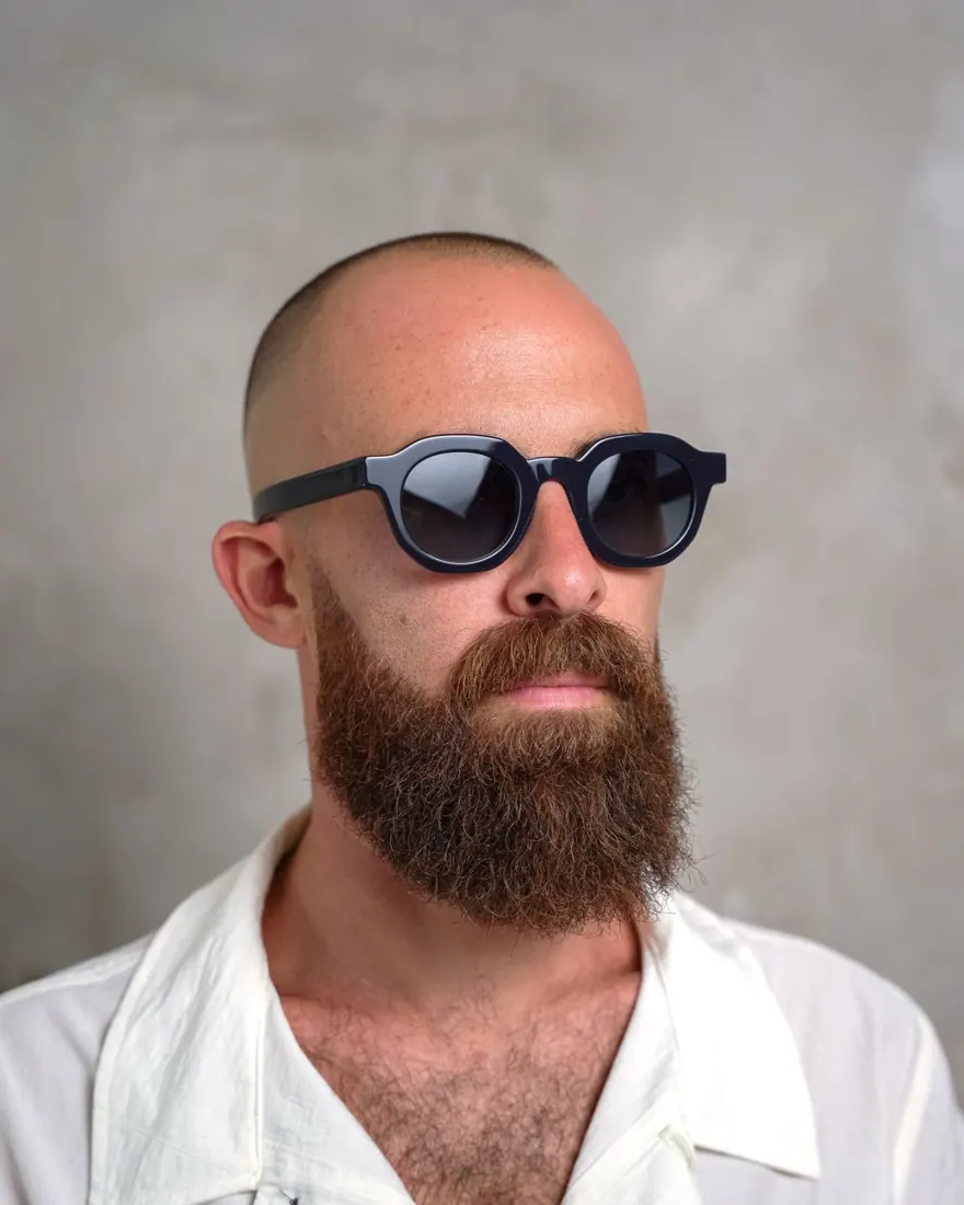 Uomo con occhiale da sole tondo nero